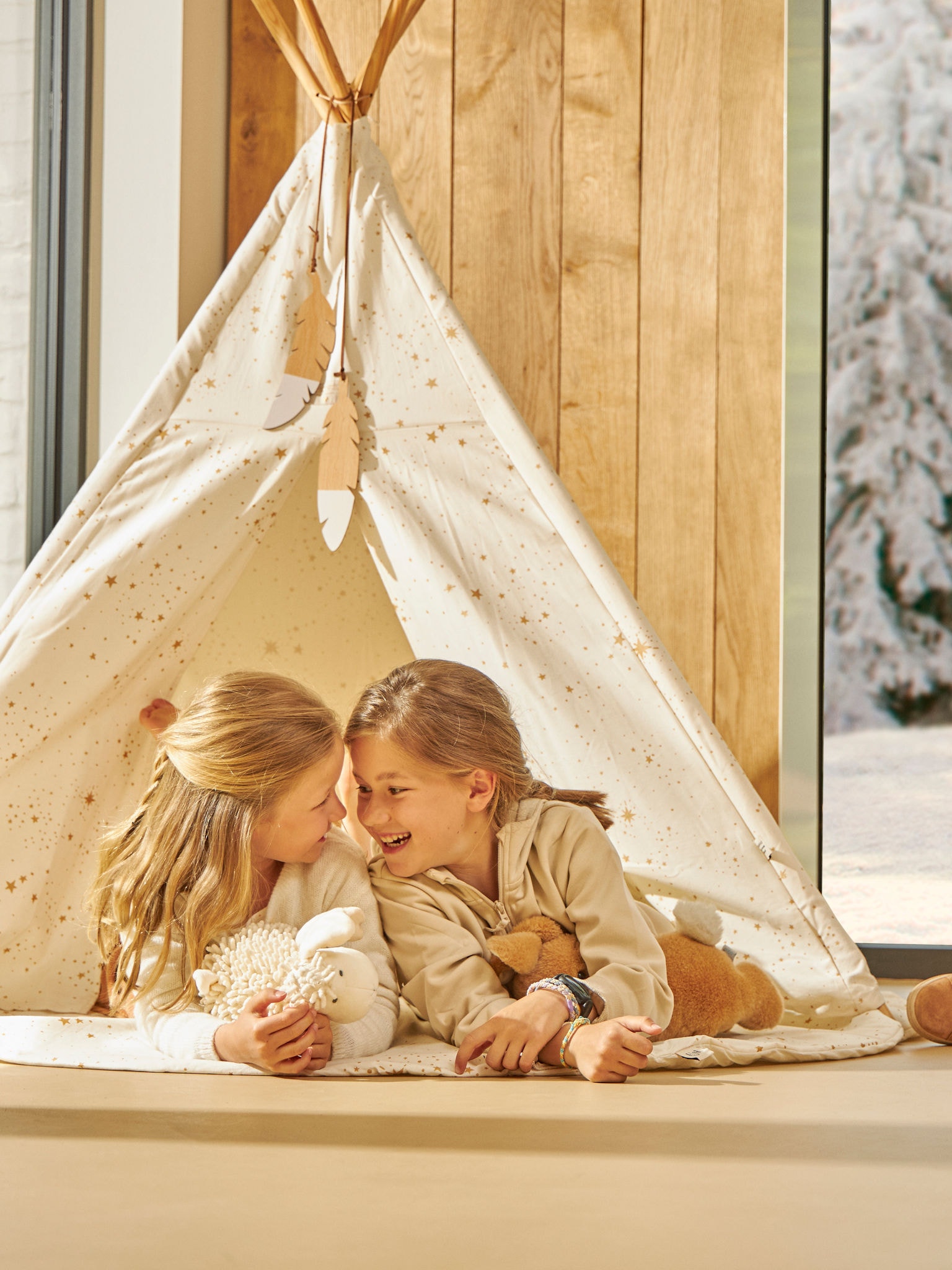 Doi copii jucându-se fericiți în cortul de interior, la temperatura perfectă