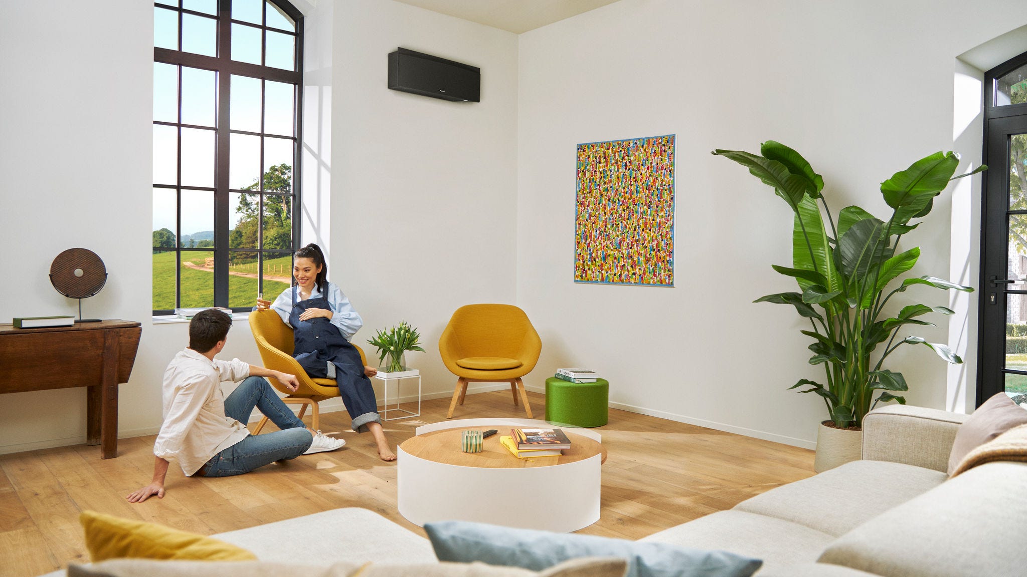 Cuplu însărcinat discutând în timp ce femeia stă pe un scaun