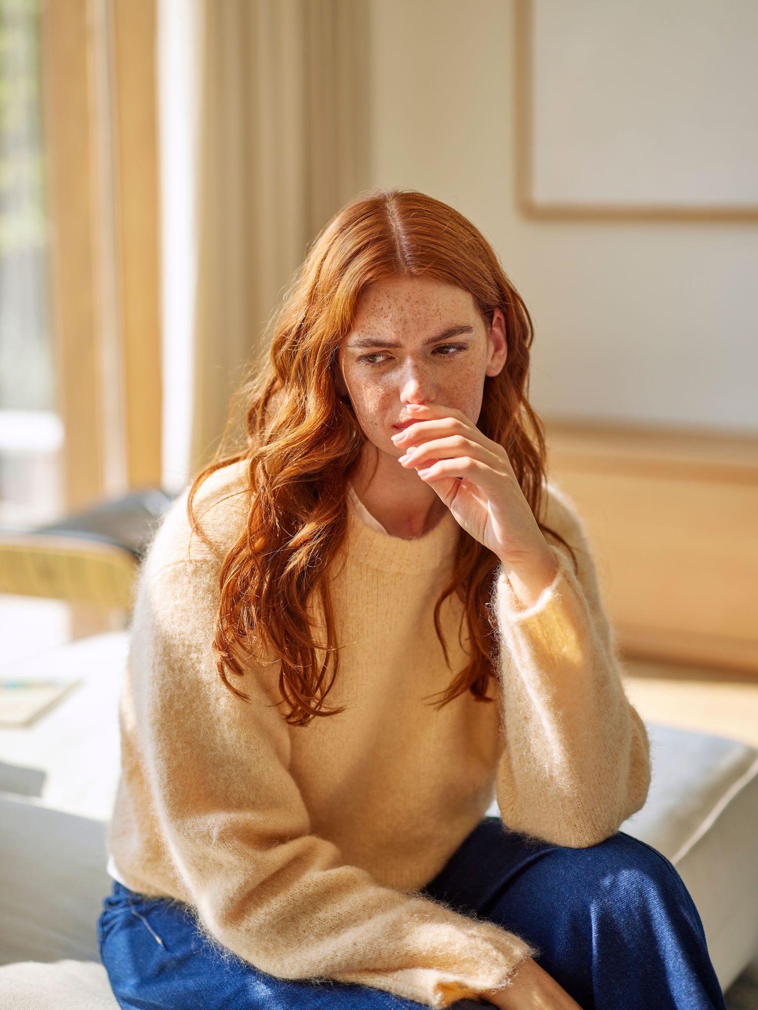 Femeie reacționând la mirosuri neplăcute de la gătit, în living