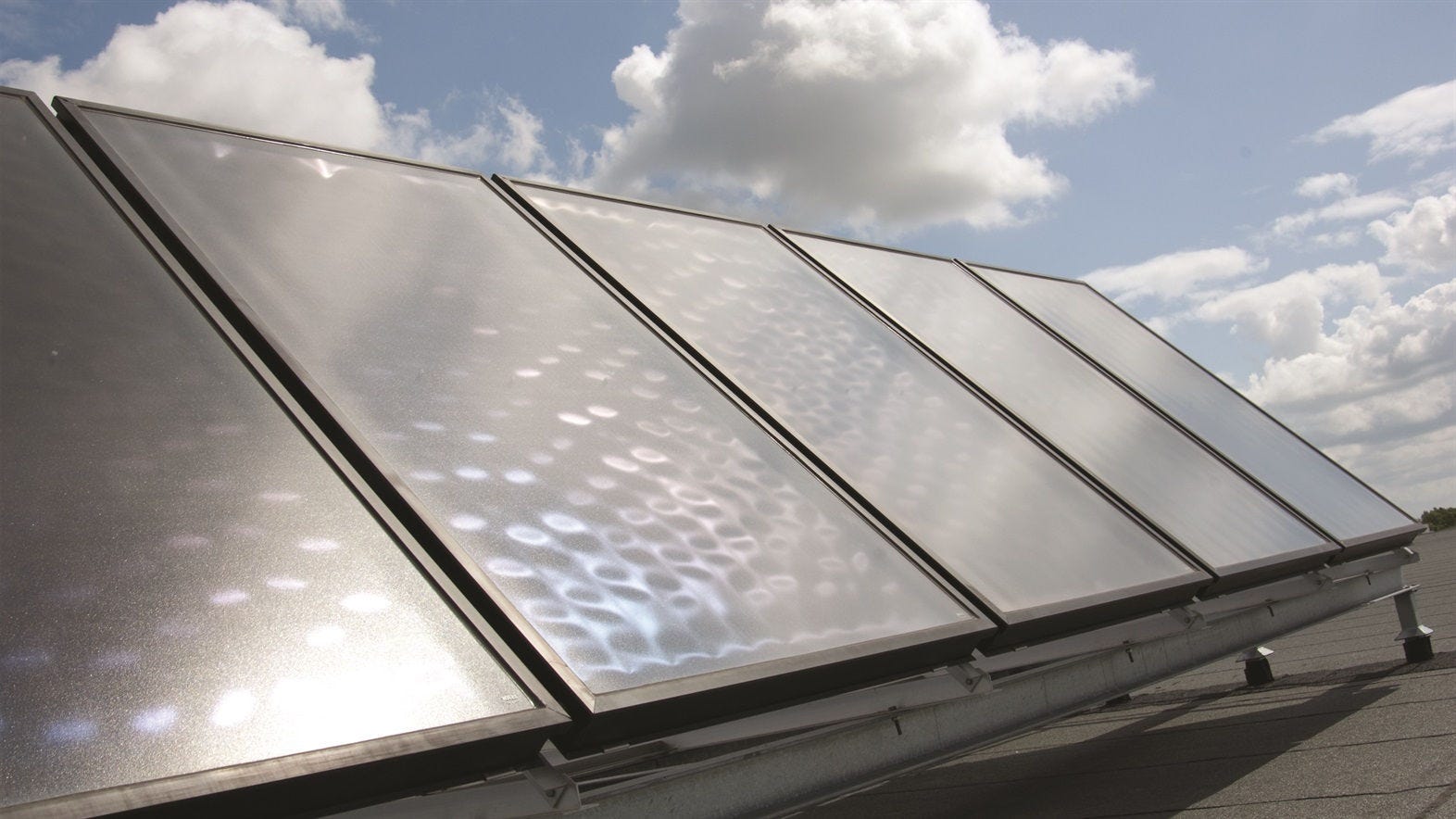 Panouri solare care alimentează o pompă de căldură Daikin pentru încălzirea eficientă energetică a unei locuințe