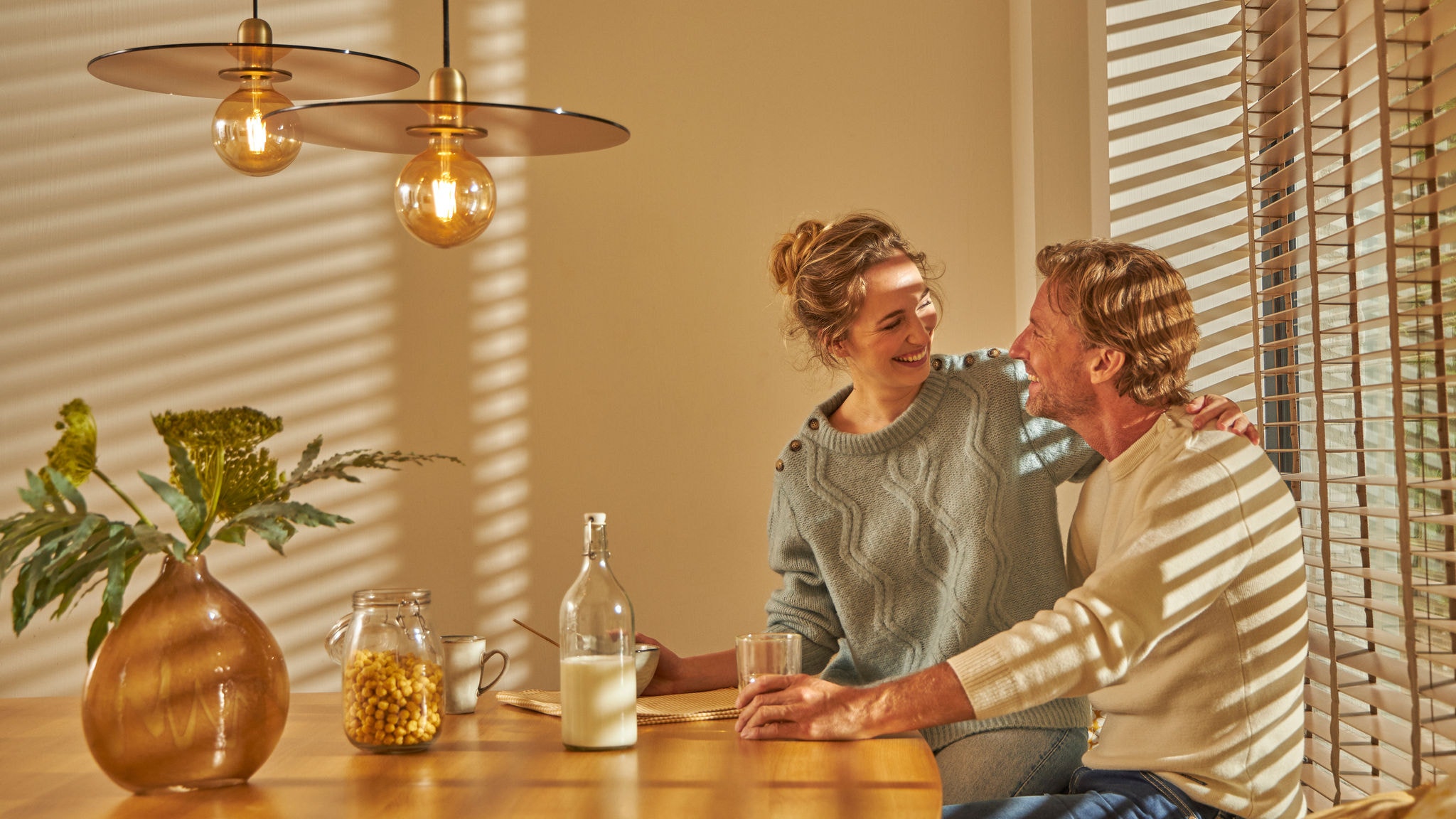 Un cuplu se bucură împreună de un mic dejun confortabil, în bucătăria confortabil de caldă, datorită acestei tehnologii intuitive de încălzire