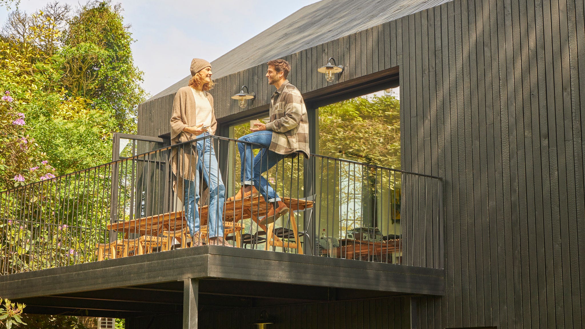 Cuplu discutând pe terasa unui bungalow în natură