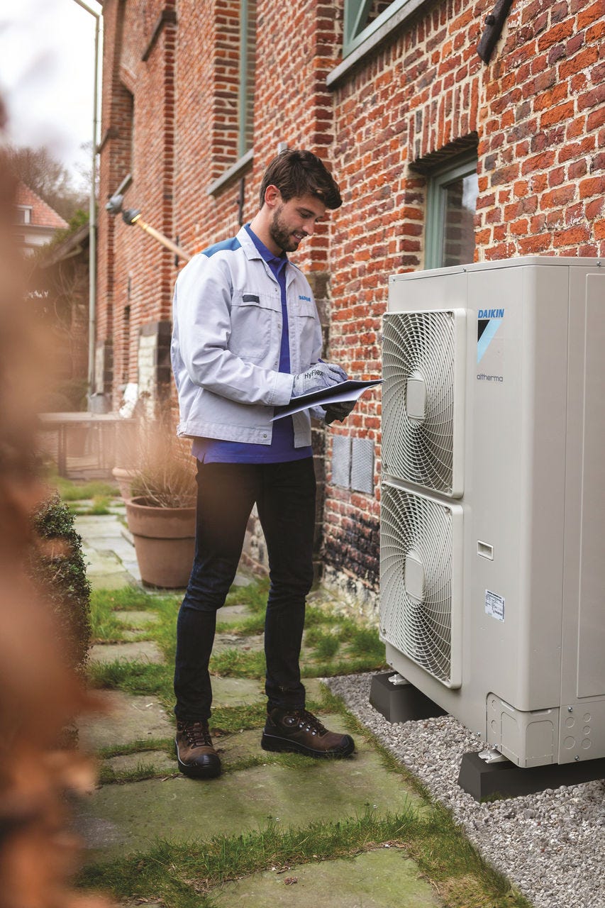 Bărbat instalând unitatea exterioară