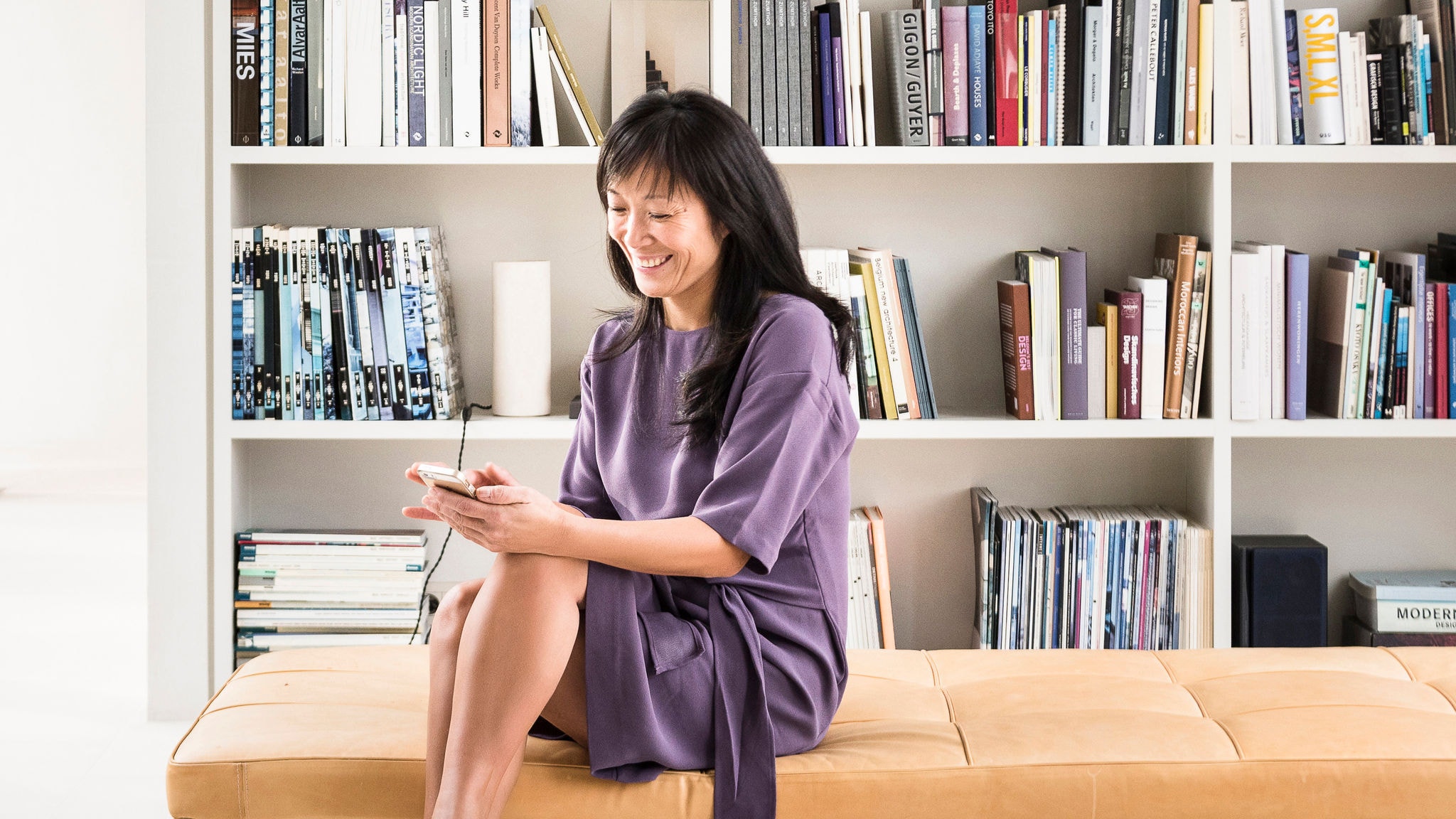 Femeie utilizând aplicația Onecta pentru a controla încălzirea, răcirea și apa caldă din casa în care locuiește