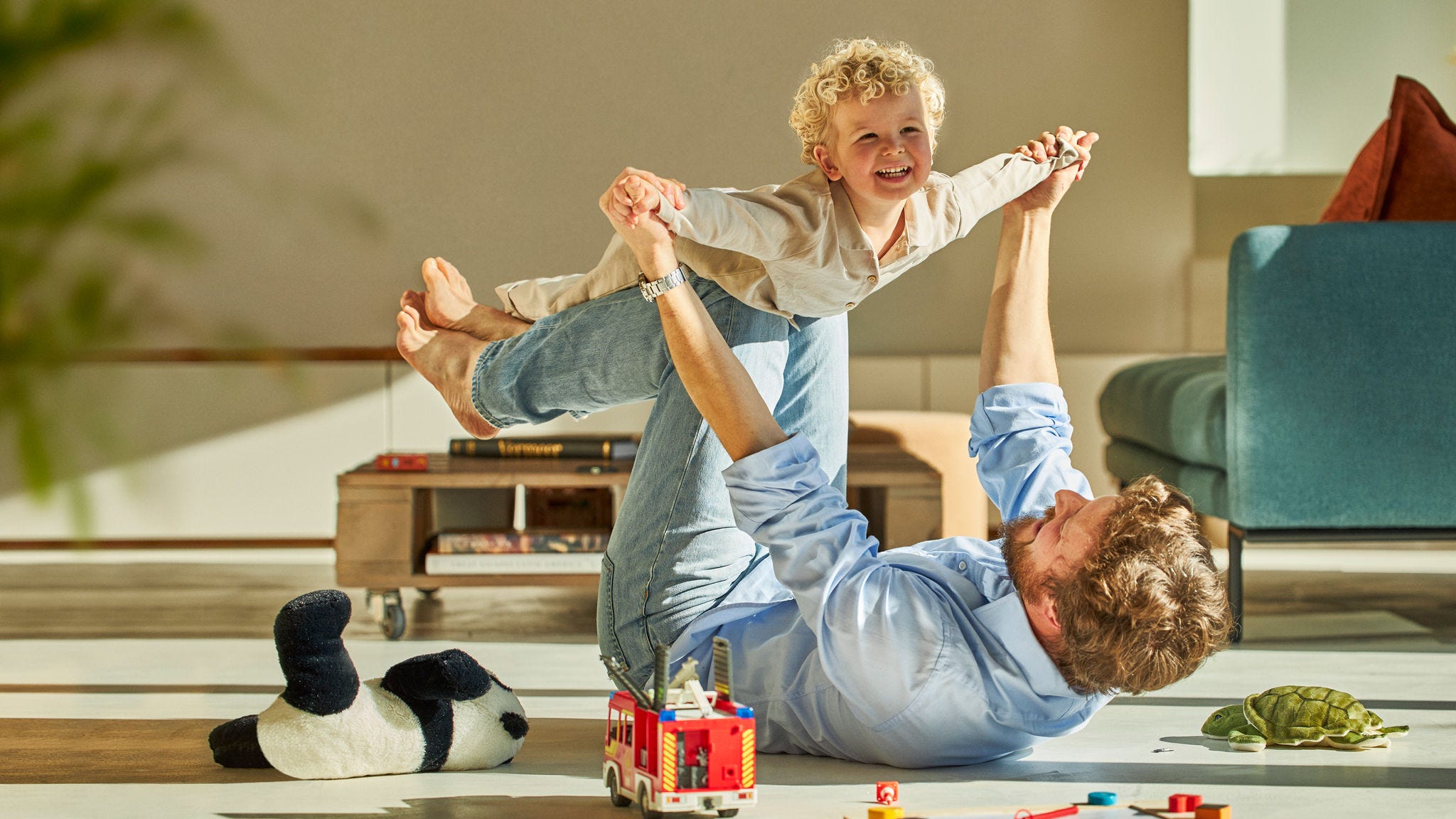 Tata jucându-se cu copilul său pe podea