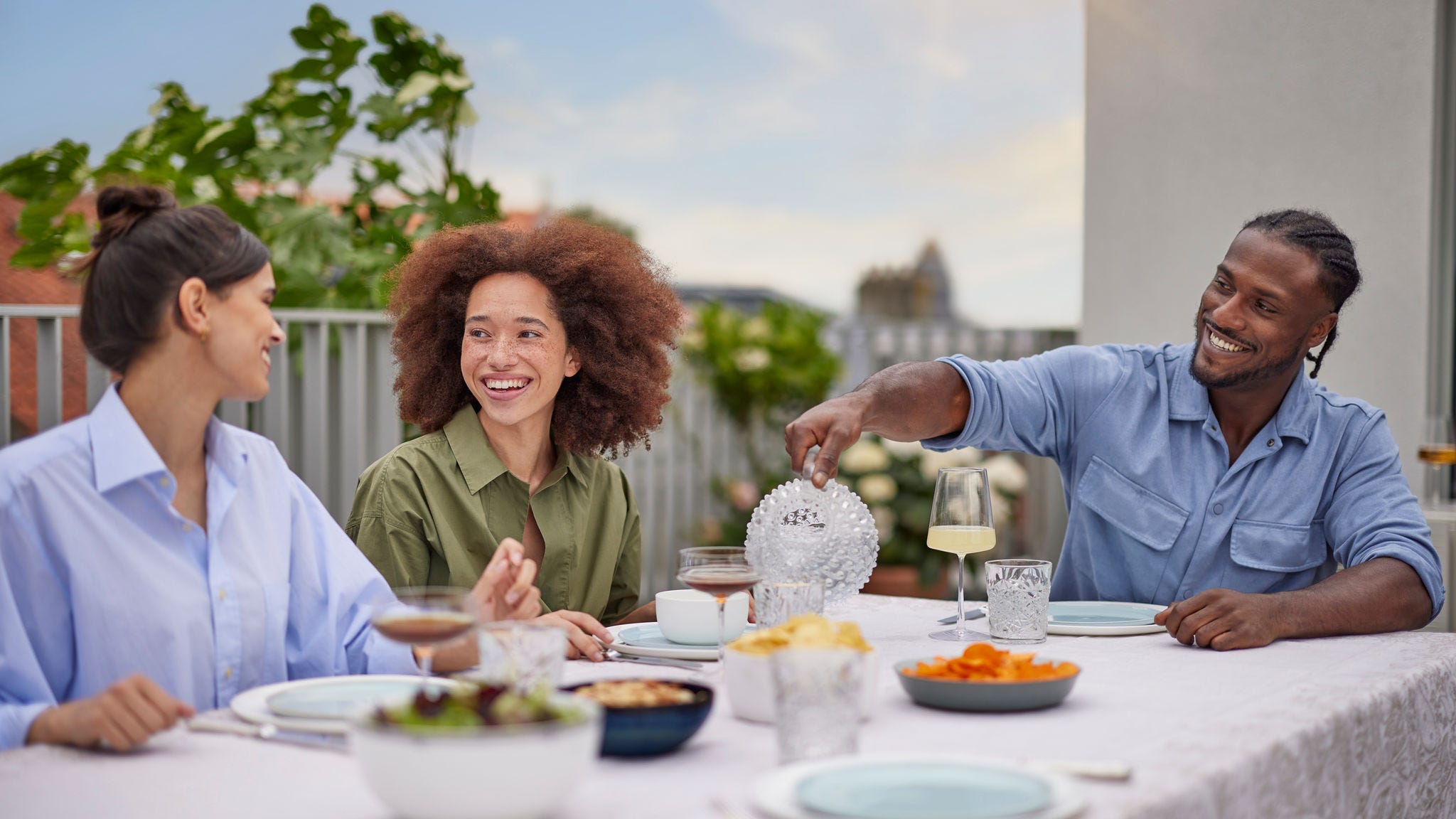 Prieteni servind cina în confort, cu o pompă de căldură cu sursă de aer silențioasă