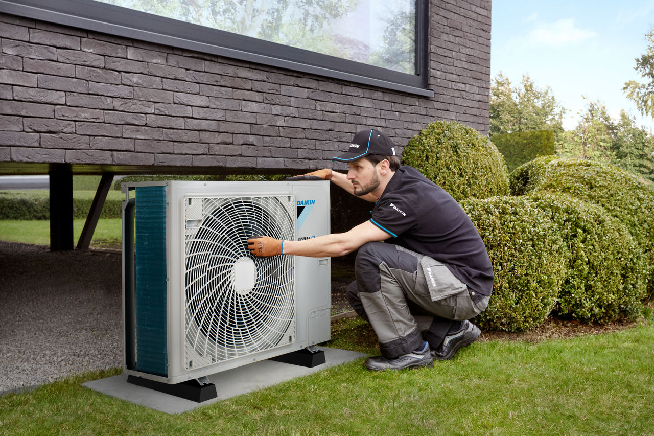 Inginer servisând o pompă de căldură Daikin